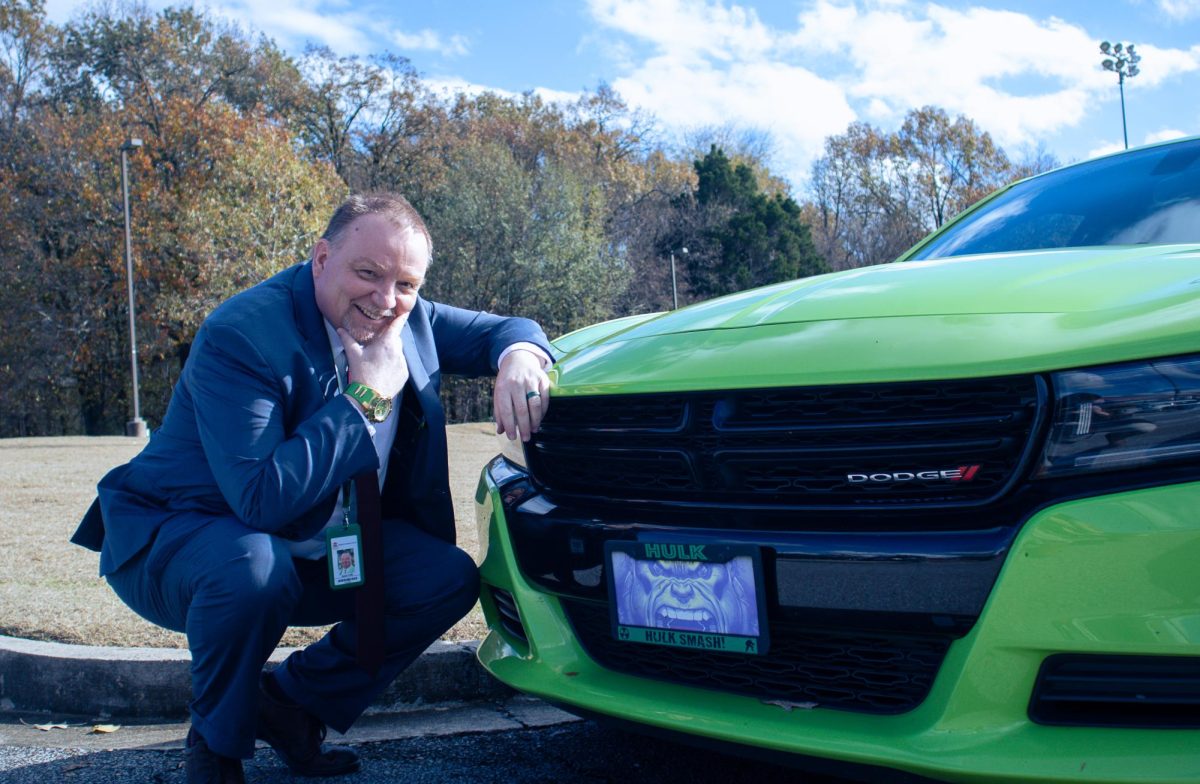 A HERO WITH A HOT RIDE: AP Statistics teacher Darin Clifft poses like a superhero with his new, hulkified Dodge Charger.