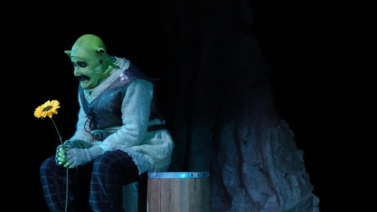 Alex Colley (12), as Shrek, gloomily gazes at a flower in the MUS production of Shrek the Musical.