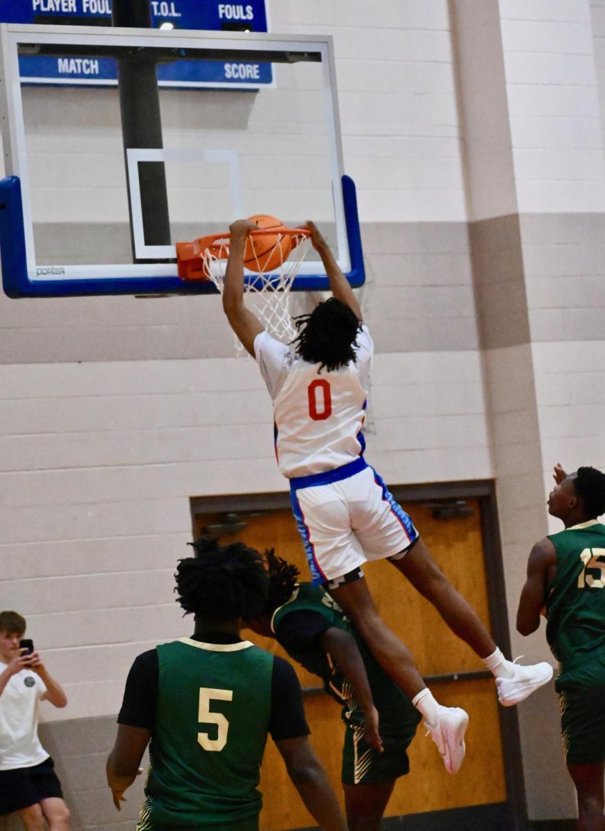 Ehi Ataga (12) soars with a massive dunk over a Booker T. player.