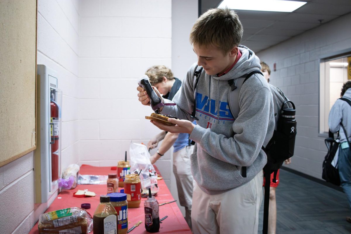 Landon Hottinger (9) makes a PB&J before practice at the sandwich bar.