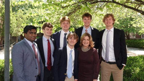 Mrs. Gates poses, surrounded by current and former students, after Chapel.